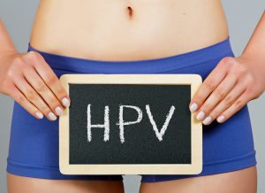 Mulher segurando uma plaquinha escrita HPV